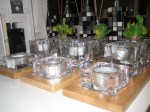 A sophisticated set with a bamboo three base with two tealights and a small pot in glass