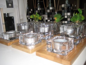 A sophisticated set with a bamboo three base with two tealights and a small pot in glass